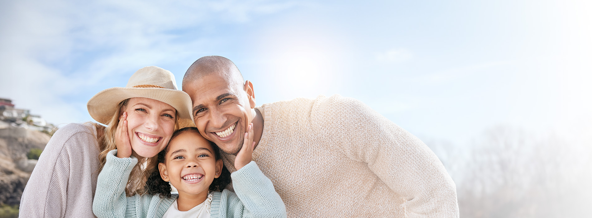 The image shows a family of four posing outdoors with natural scenery behind them, likely on vacation.