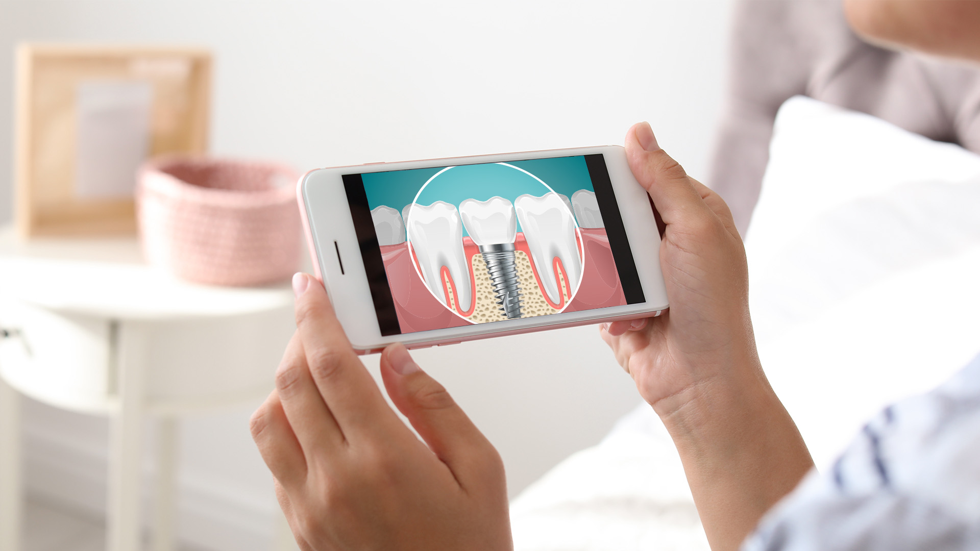 The image shows a person using a smartphone to display an illustration of a tooth with a cavity on a screen, likely for dental education or promotion purposes.