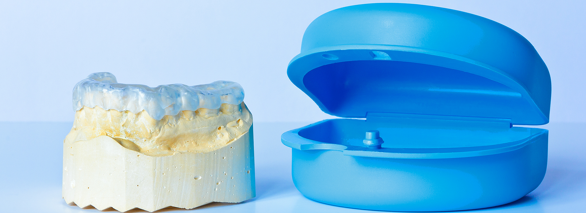 The image shows two dental implants with blue caps on top, placed next to each other against a white background.