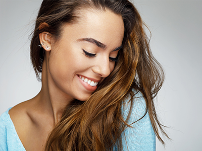 A composite image featuring two photographs of a woman with long hair smiling, one on the left showing her profile and the other on the right showing her looking directly at the camera.