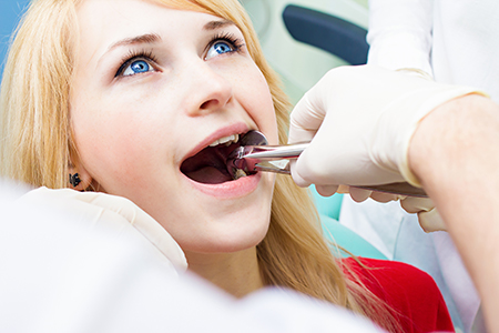 A woman receiving dental treatment with a dentist performing the procedure.